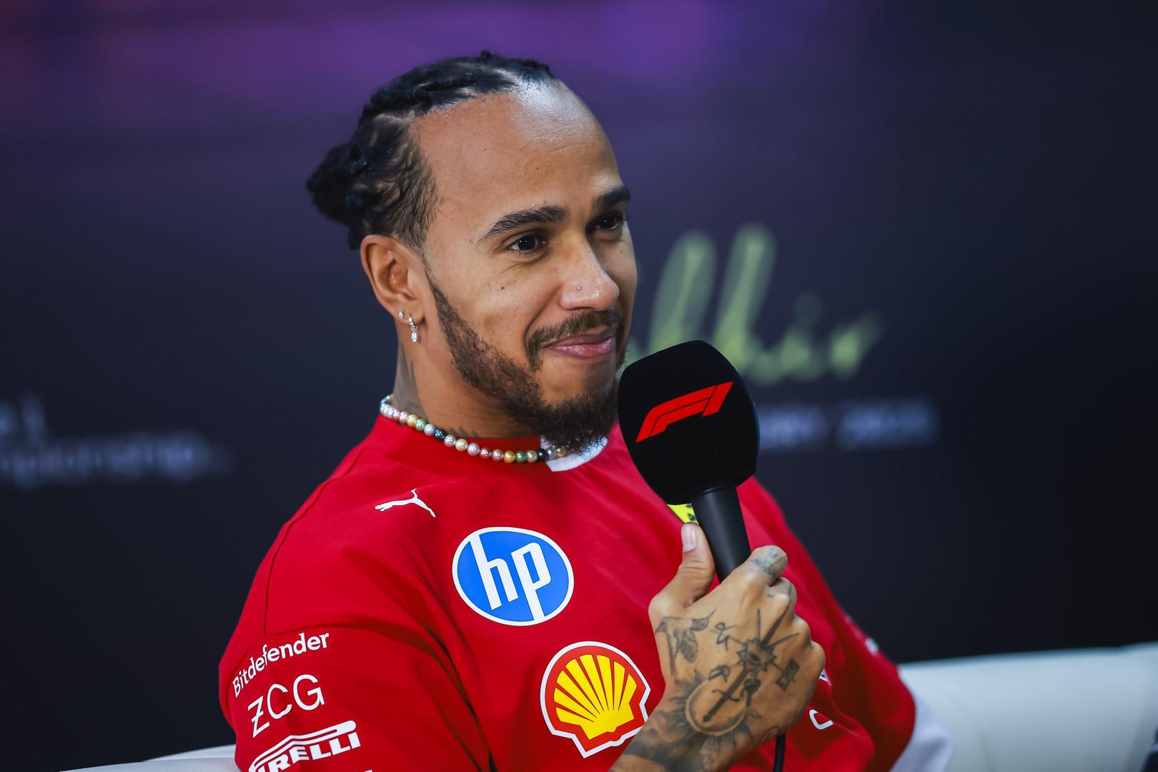a man in a red shirt holding a microphone